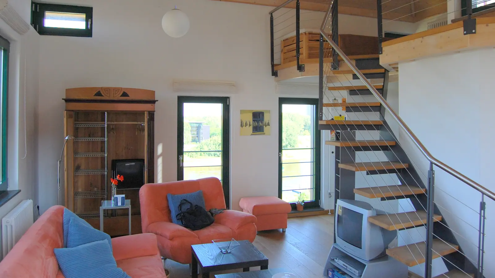 Heller Wohnraum mit Sofas und offener Treppe