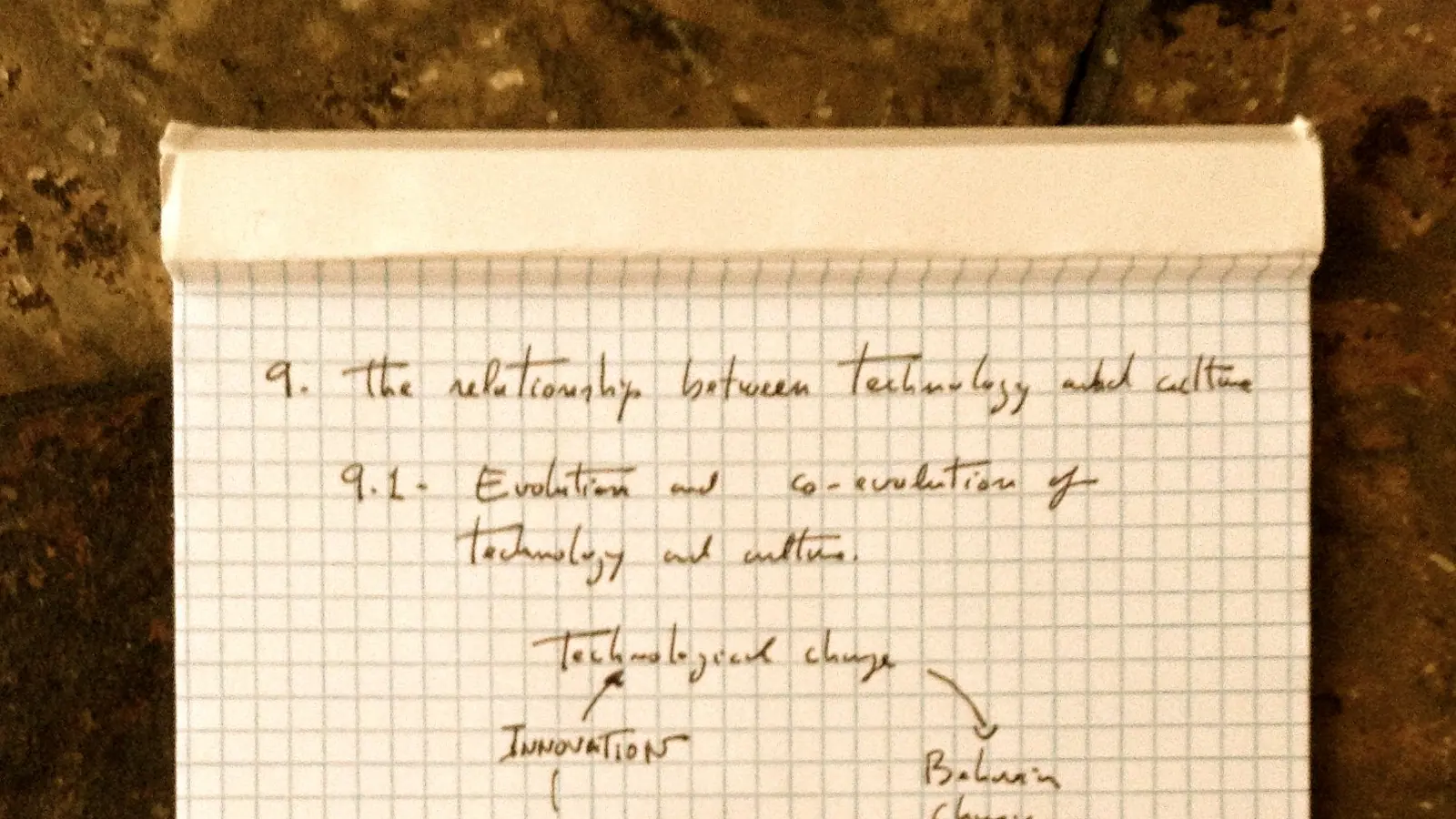 Handschriftliche Notizen auf kariertem Papier neben einem Füllfederhalter